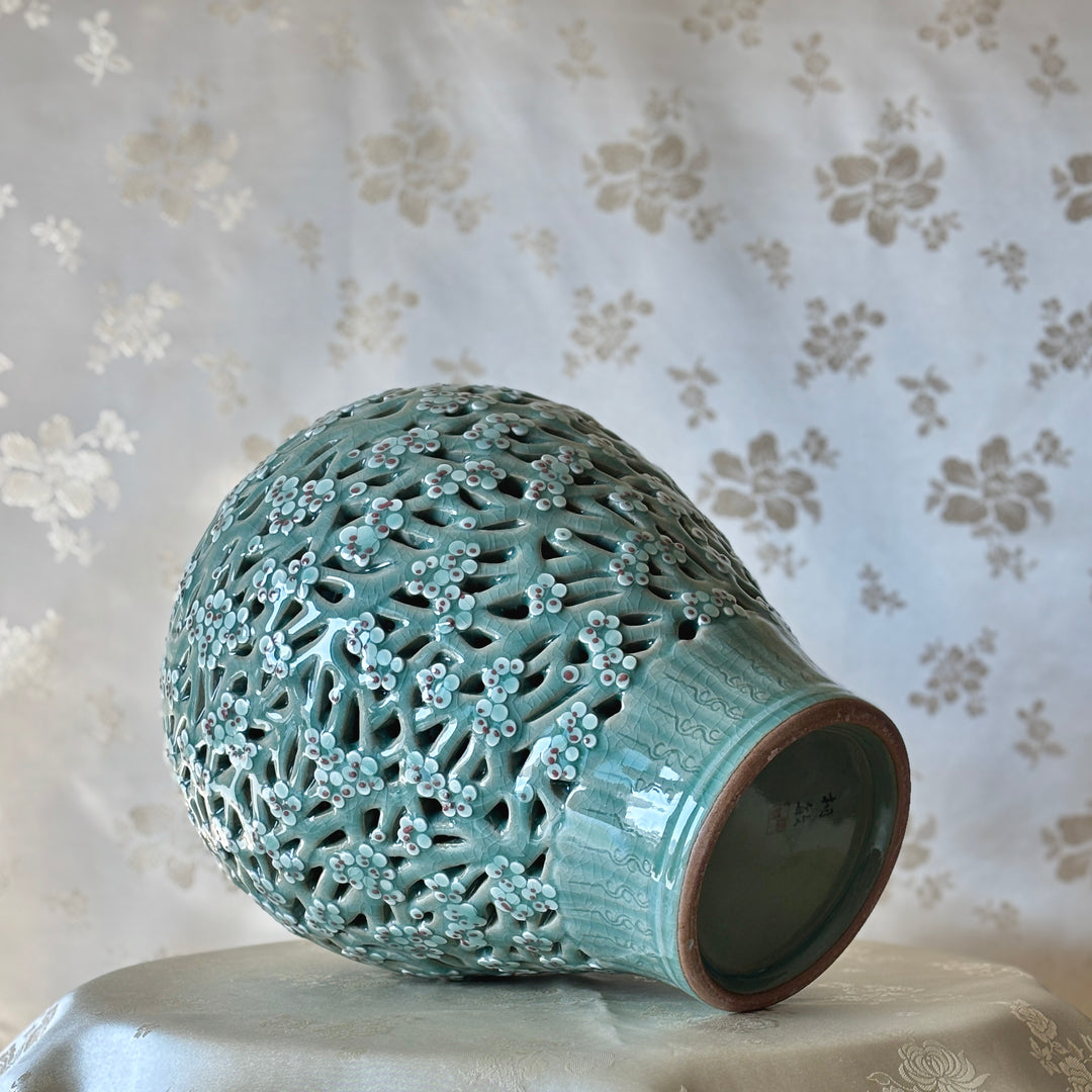 Handmade Korean celadon double-wall openwork vase featuring intricate plum blossom motifs in white and red, showcasing traditional craftsmanship.