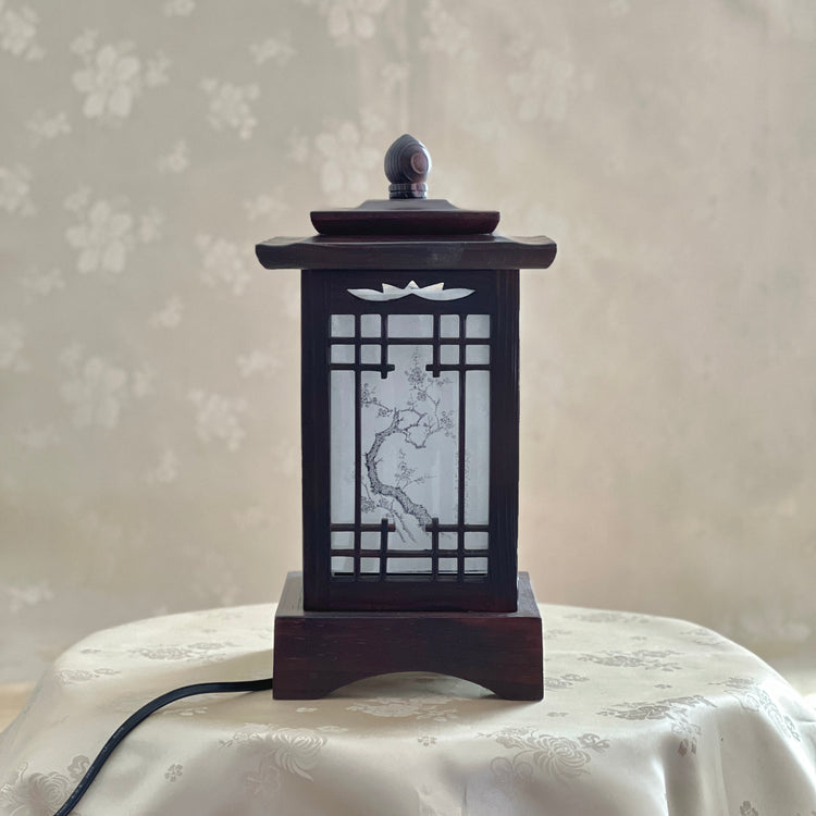 Front view of a handmade Korean traditional wooden table lamp with a square pagoda-shaped roof and Sagunja patterns.