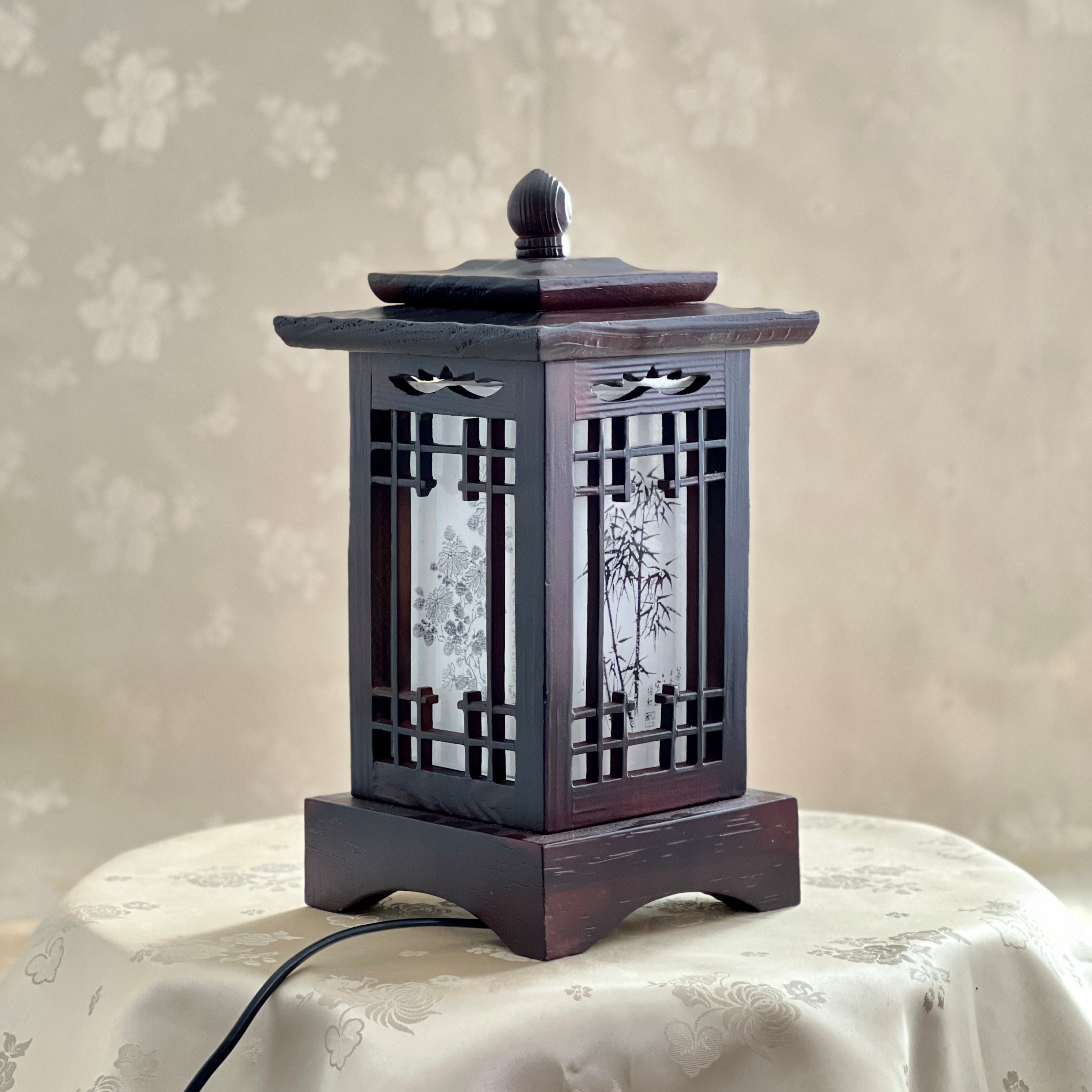 Front view of a handmade Korean traditional wooden table lamp with a square pagoda-shaped roof and Sagunja patterns.