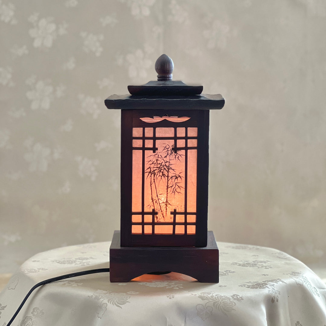 Front view of a handmade Korean traditional wooden table lamp with a square pagoda-shaped roof and Sagunja patterns.