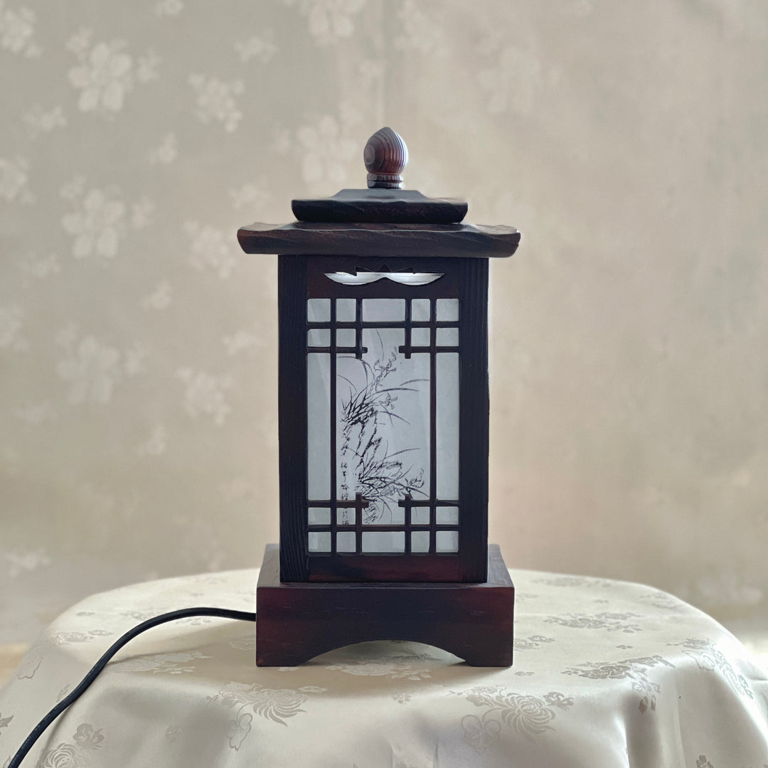 Front view of a handmade Korean traditional wooden table lamp with a square pagoda-shaped roof and Sagunja patterns.