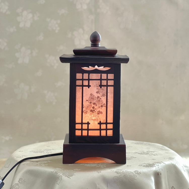 Front view of a handmade Korean traditional wooden table lamp with a square pagoda-shaped roof and Sagunja patterns.