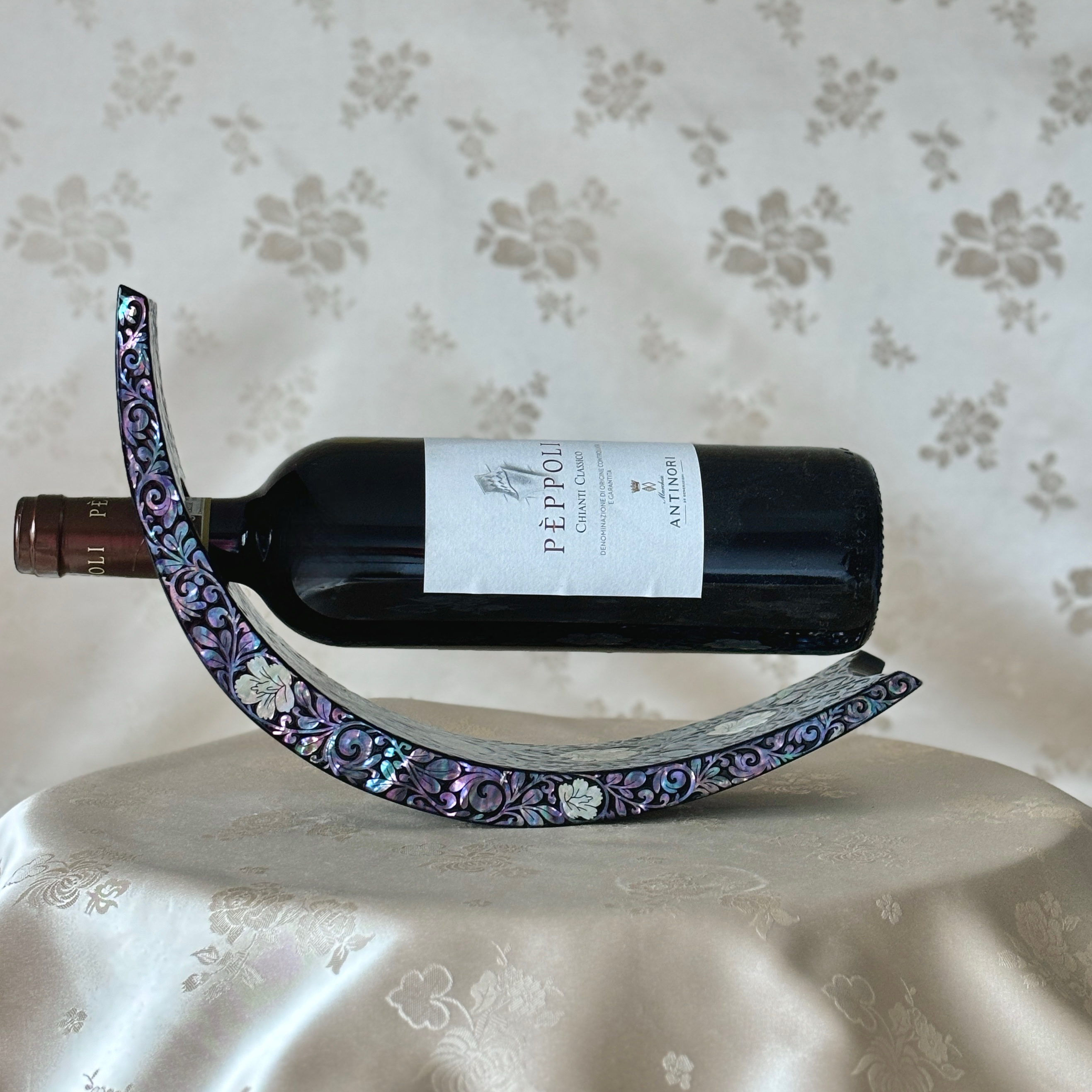 Korean mother of pearl wine holder with a wine bottle placed in the holder, demonstrating how to use it.