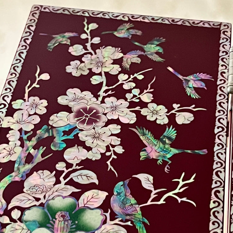 Korean Traditional Handmade Mother of Pearl Black Color Wooden Folding Screen on a table, featuring a pattern of birds, butterflies, and flowers.